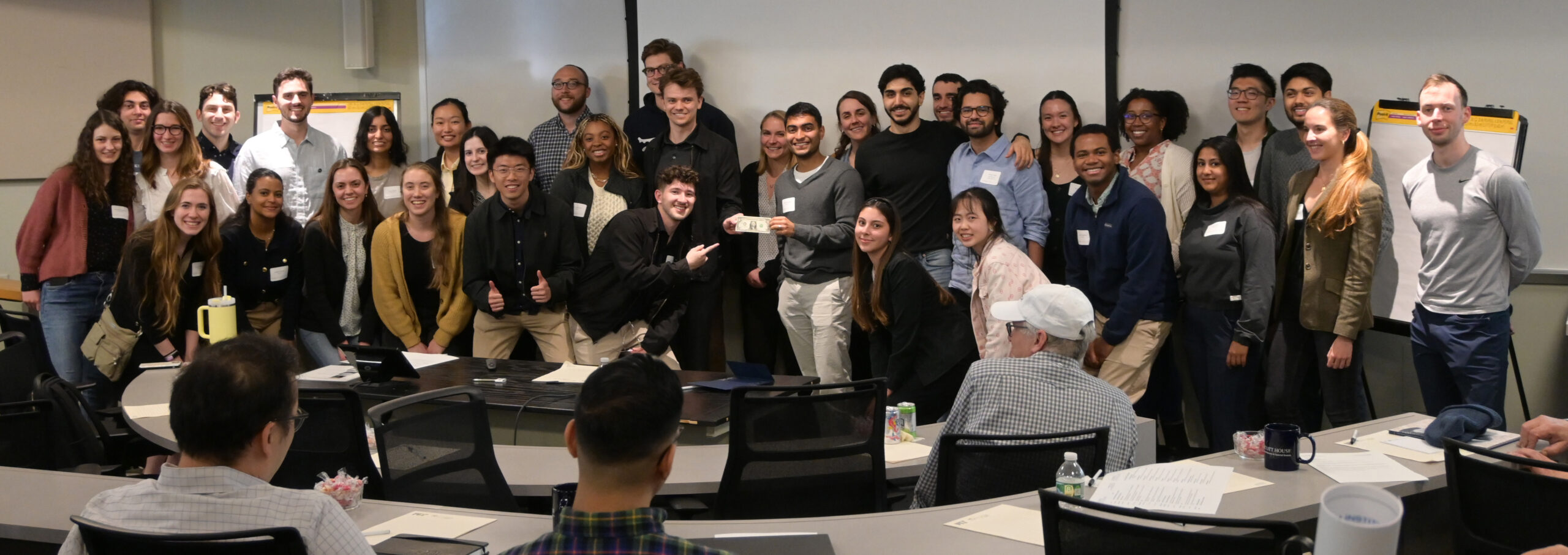 Graduate students of Ludwig MIT show off the cherished Ludwig Buck (center), awarded to the group that asked the most questions at the retreat.